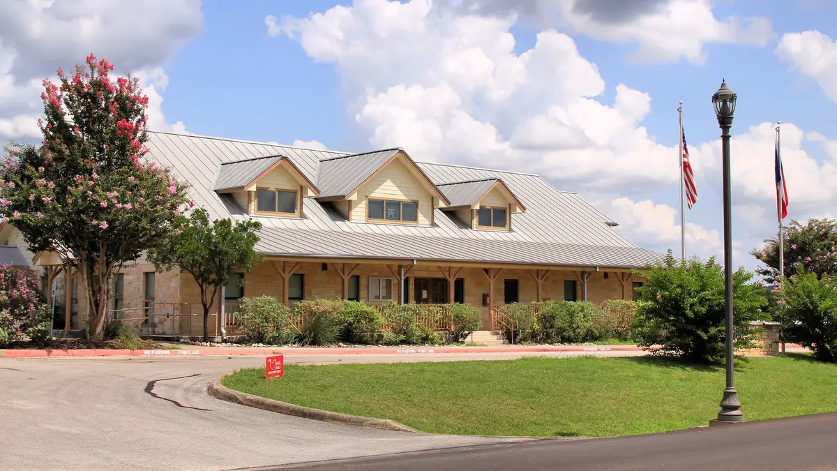 Bulverde City Hall on Cougar Bend, a low stone and metal building with a covered entry and flagpoles