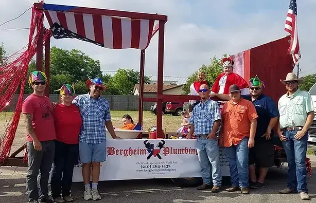The Bergheim Plumbing crew and their families standing with the parade float