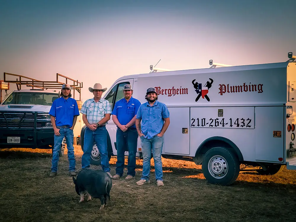 Four Bergheim Plumbing technicians standing in front of the service van at sunset