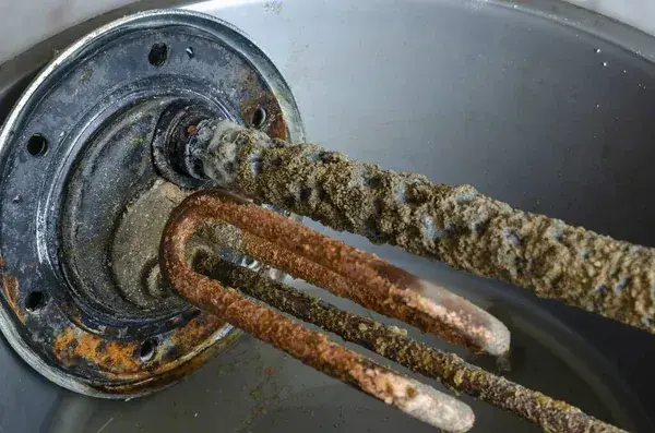 Heating element caked in heavy limescale removed from a water heater