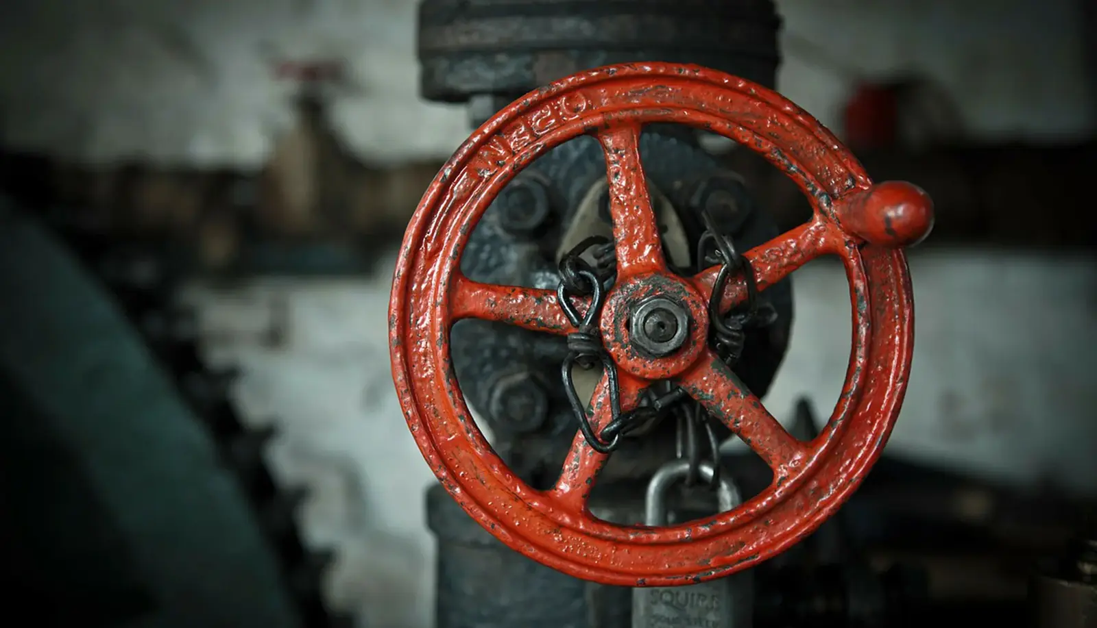 A red wheel handle on a cast iron water valve