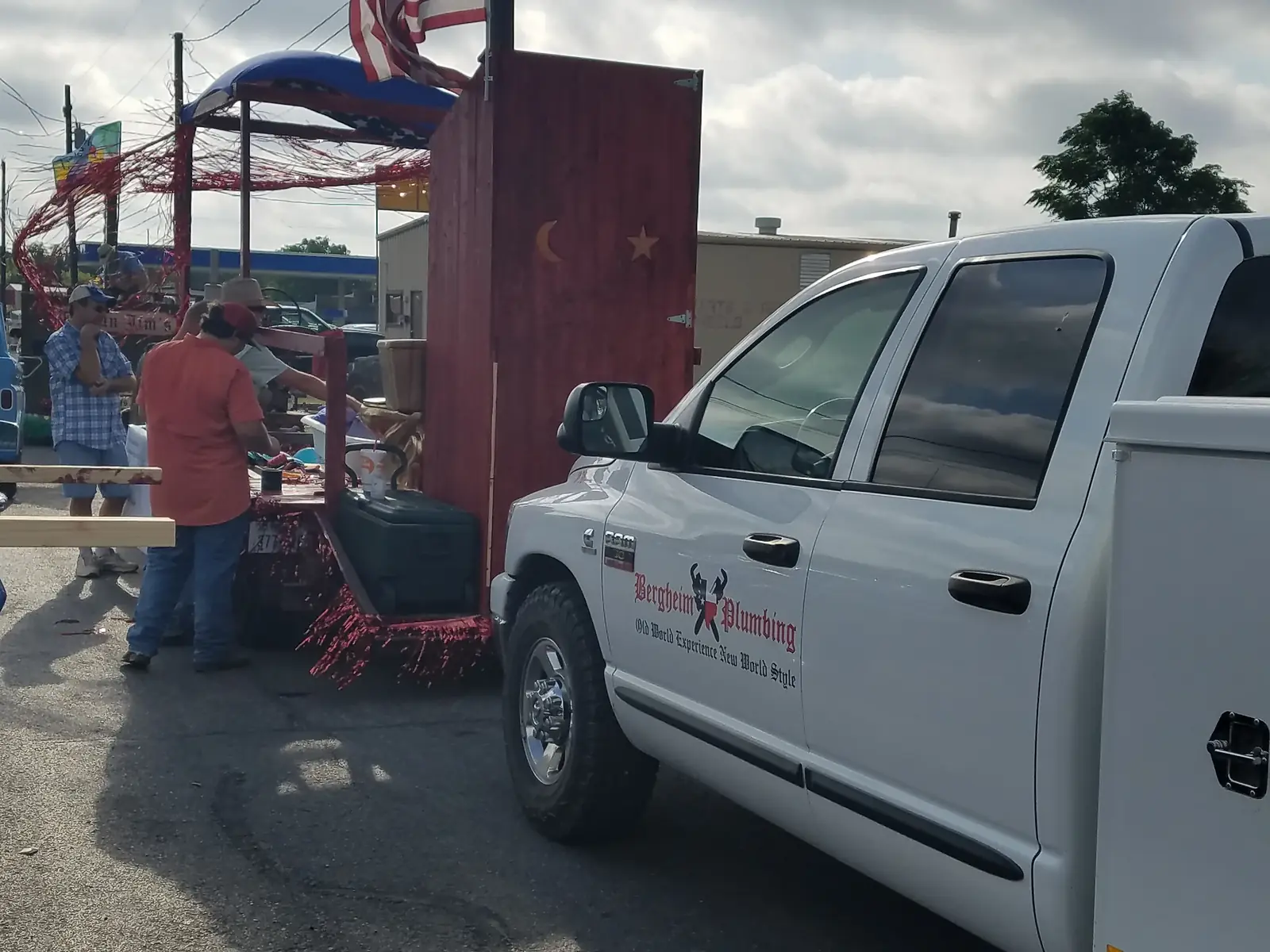 Bergheim service truck parked beside the red parade float before the procession