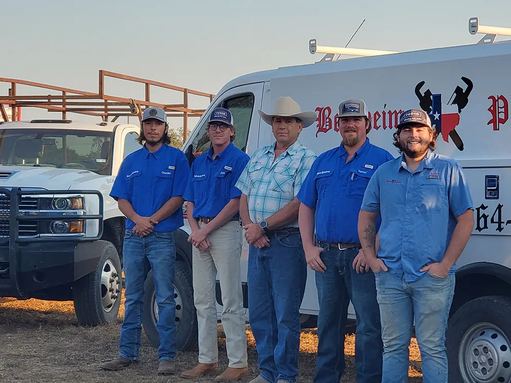 Crew of five standing along the side of the lettered Bergheim Plumbing van